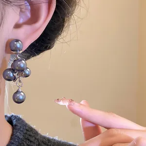 Detailed shot of vintage style charcoal grey pearl grape cluster earrings on model