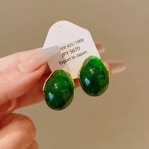 Vintage emerald green drop earrings with gold trim and minimalist geometric design.