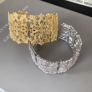 Detalle de los intrincados patrones de filigrana en brazaletes anchos de oro y plata