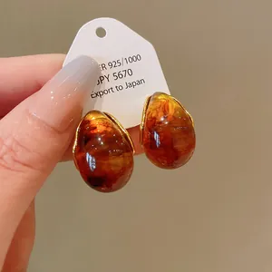 Macro detail of vintage amber-toned waterdrop earrings with elegant gold accents