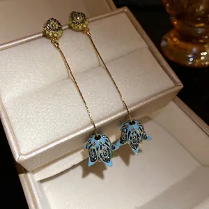 Orecchini bohémien a nappa con fiori in smalto blu e strass scintillanti per uno stile chic.