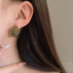 Close-up of a vintage Maillard teardrop earring worn on ear, showing grey resin detail.