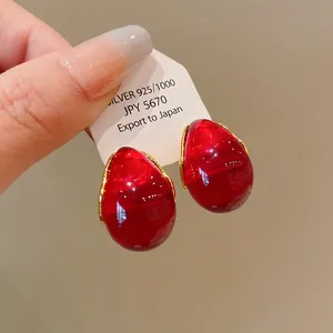 Detailed close-up showing the texture of vintage red teardrop earrings with gold edges