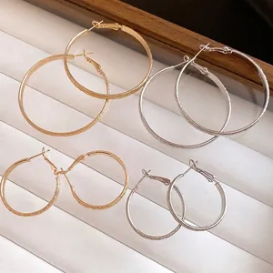 Elegant gold and silver textured hoop earrings with silver needles for jewelry collection