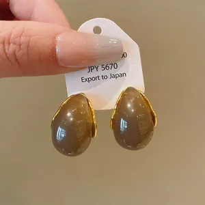 Detail view of retro Maillard style water-drop earrings with elegant gold trim.