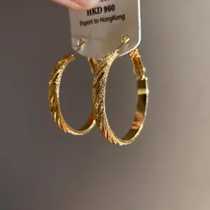 Gold hoop earrings with textured diagonal stripes and 925 silver needles