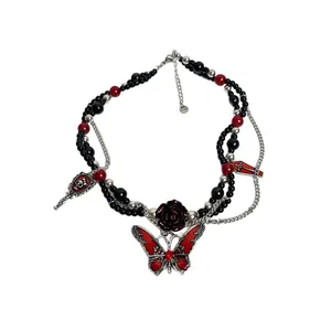 Collar gótico oscuro con mariposa roja, rosa y cuentas negras en fondo blanco