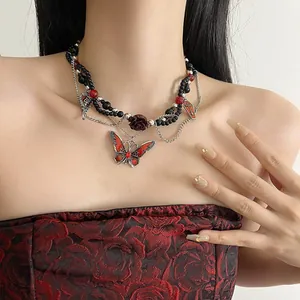 Detalle del collar de mariposa gótica con cuentas negras y detalles de rosa roja