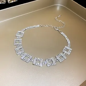 Dettaglio di una lussuosa collana girocollo argentata con maglie quadrate in strass scintillanti