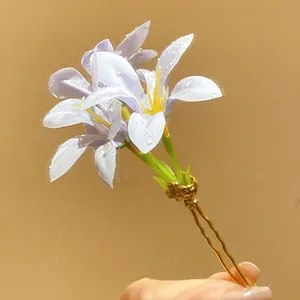 Detailed macro view showing delicate purple fabric flower petals on a golden hair pin