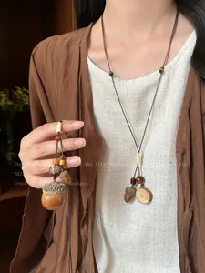 Detailed view of handmade ethnic acorn necklace with adjustable wax rope and wood beads