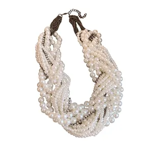 Elegant multi-layer knotted pearl necklace with sparkling rhinestone accents on white back.