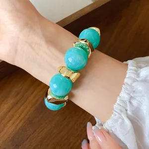 Bracciale a sfere in acrilico marmorizzato con accenti irregolari in metallo dorato.