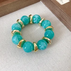 Dettaglio del bracciale in acrilico marmorizzato con distanziatori in metallo dorato