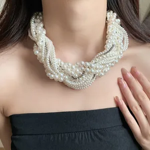 Close-up of a multi-layer pearl necklace with rhinestone accents on a model's neck.