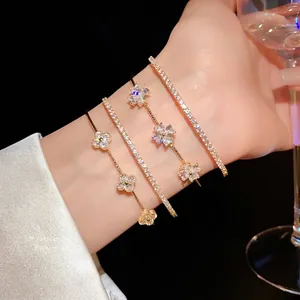 Elegant set of four gold-toned cubic zirconia tennis and clover flower bracelets on wrist