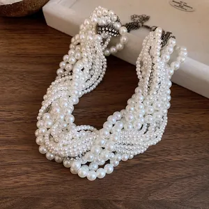 Close-up of multi-layered knotted pearl necklace with rhinestones on wood