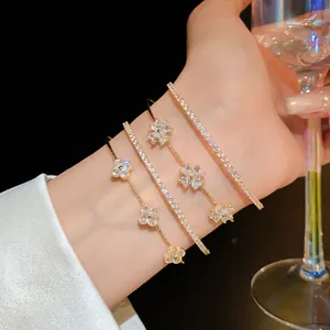 Elegant close-up view of shimmering zircon four-leaf clover and tennis bracelets on model's wrist