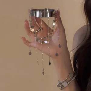 Detailansicht eines silbernen Metallarmbands mit Troddeln und runden Pailletten