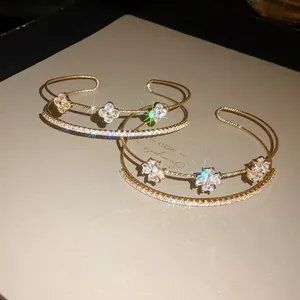 Detailed macro shot of zircon-encrusted gold flower bangles with sparkling light effects.