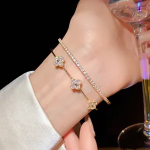 Detailed view of elegant gold zircon flower bracelet and tennis bracelet layered on wrist