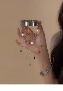 Detailansicht eines eleganten Armreifs mit silbernen Pailletten-Quasten für Damen