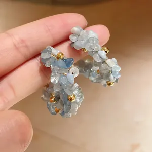 Primo piano dei cerchi fatti a mano con scaglie di acquamarina blu e perline dorate lucide
