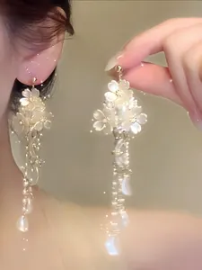 Close-up detail showing exquisite French style shell flower and pearl long tassel earrings