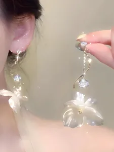 Close-up of French shell flower earrings with sparkling pearl and crystal detail