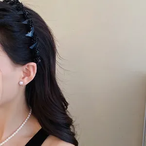 Elegant black netting wrapped headband with glass beads for a high top hairstyle.