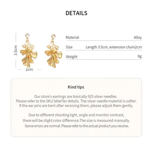 Detailed view of ginkgo leaf earrings with 925 silver needles and gold finish texture.