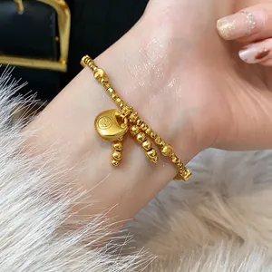 Detailed macro shot of a gold-plated charm bracelet featuring a traditional Chinese lock.