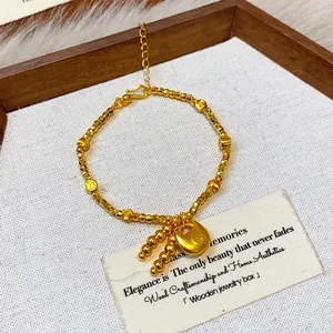 Detailed view of the gold-plated lock charm and beads on a Chinese-style bracelet