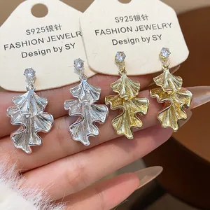 Detail of crumpled leaf dangle earrings in gold and silver with S925 silver needles.