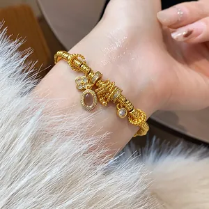 Detailed close-up of a gold-plated lock charm bracelet with sparkling crystal accents