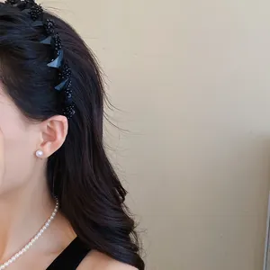 Detail view of black beaded mesh headband worn by model for elegant hair styling effect