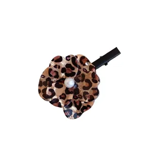 Elegant flower hair clip with leopard print and pearl accent on white background