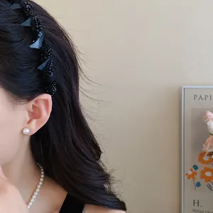 Detail view of a stylish black mesh wrapped glass bead headband for high skull top look