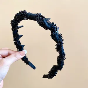 Close-up of elegant black mesh-wrapped headband with sparkling glass beads and inner teeth.