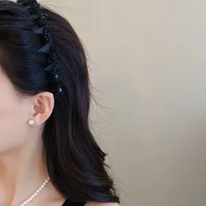 Detail view of the black mesh-wrapped headband with sparkling glass bead accents