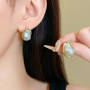 Close-up of elegant S925 silver needle earrings with pleated faux pearls in gold frame