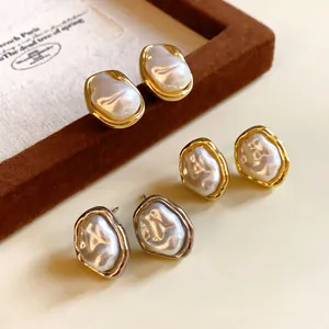Detailed macro view of retro irregular baroque pearl earrings in gold and silver finish