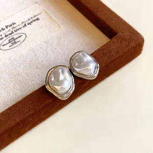 Detailed macro shot of French vintage irregular wrinkled faux pearl stud earrings in silver
