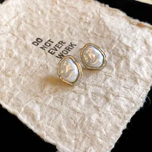 Detailed macro view of French retro pleated faux pearl stud earrings with silver metal base
