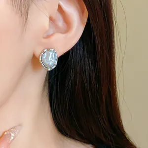 Close-up of vintage irregular baroque pearl stud earrings shown on a model's ear