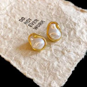 Detail of French retro irregular gold-plated stud earrings with elegant faux pearls