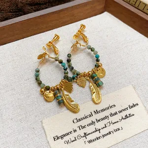 Orecchini etnici vintage placcati oro con perle in pietra verde e pendenti a piuma