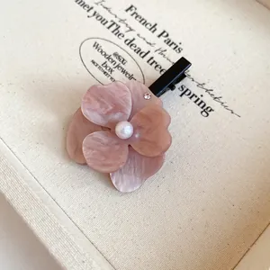 Close-up of elegant dusty pink marble acrylic flower hair clip with pearl center detail.