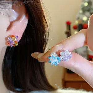 Detailed close-up view of vibrant crystal flower stud earrings in blue and purple tones