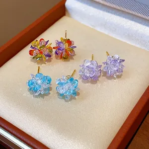 Detailed view of three pairs of sparkling crystal flower stud earrings in a jewelry box